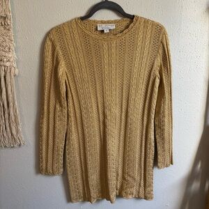 This is a St. John Collection metallic gold cable knit long sleeve sweater